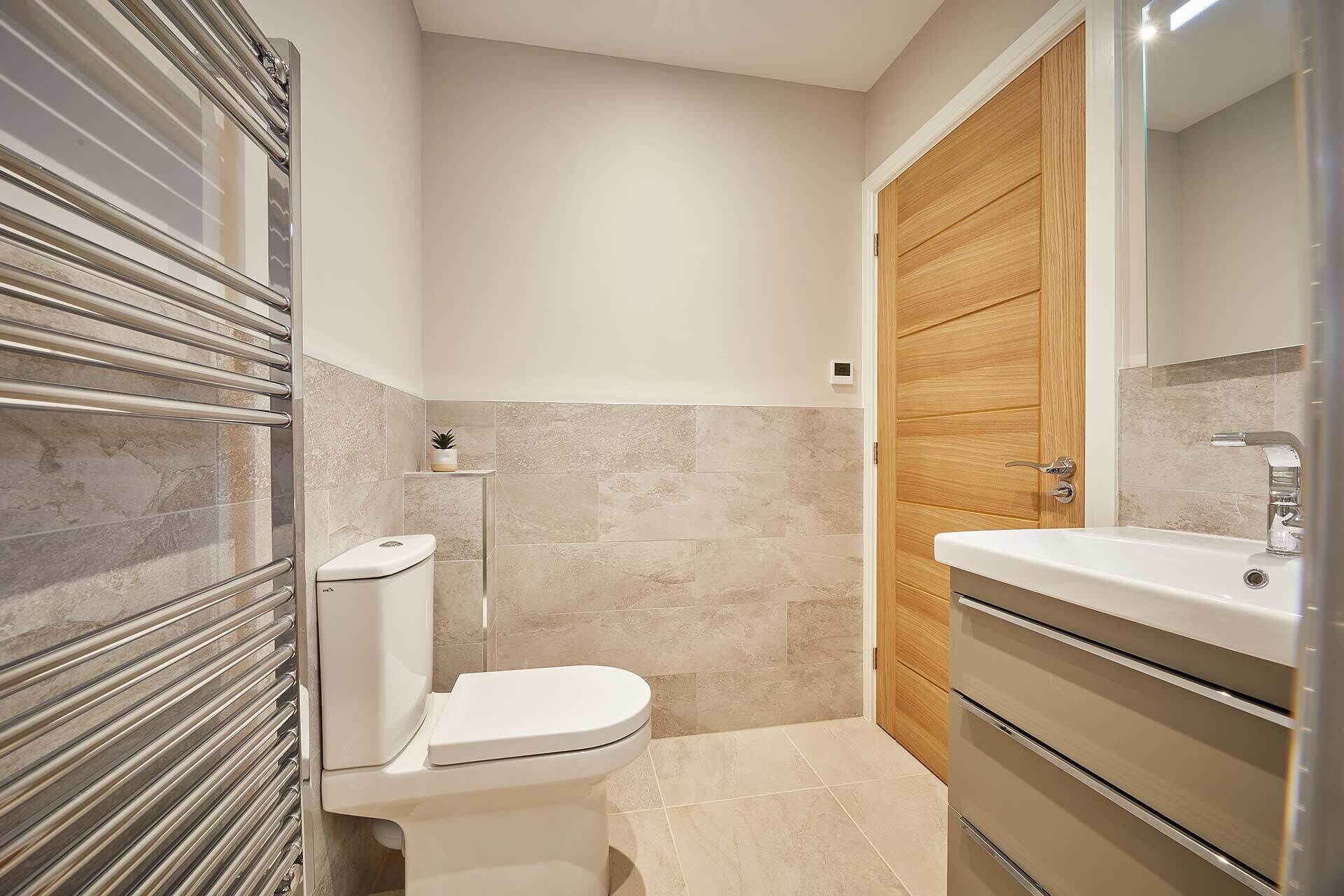 A bathroom with a toilet, a sink, and a mirror.
