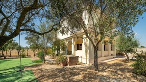 Une villa dotée d’un patio, d’oliviers et offrant une vue sur un ciel dégagé.