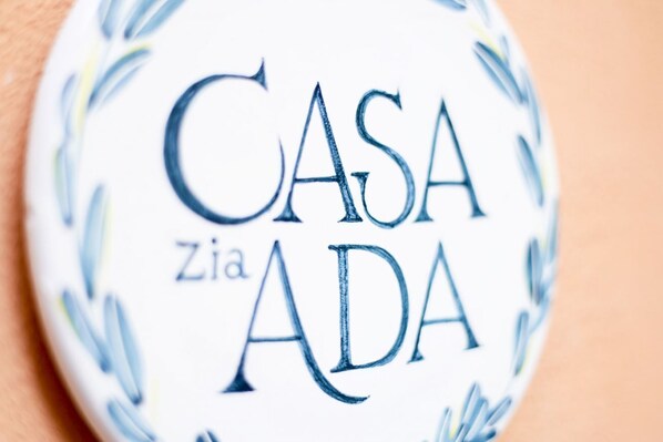 Et nærbillede af en rund genstand med teksten 'CASA ZIA ADA' trykt på.
