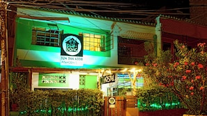 A hostel with a green and white facade, a signboard, and a gated entrance. - Ding-Dong Hostel (Cali)