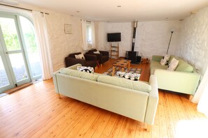 Relax in this stylish living area with a large sofa, smaller sofa, and flat-screen TV.