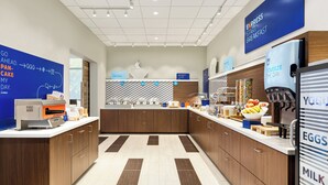 A modern breakfast area with a self-service station, a refrigerator with yogurt and milk, and a sign indicating a breakfast menu. - Holiday Inn Express & Suites Hayward - Castro Valley by IHG (Hayward)