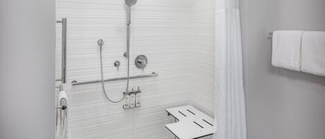A modern shower with a handheld showerhead, a wall-mounted faucet, and a glass-enclosed shower area.