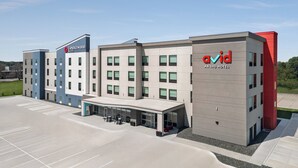 Un hôtel moderne composé de plusieurs bâtiments, dont une partie est identifiée par l’enseigne « Candlewood Suites » et une autre par l’enseigne « Avid, un hôtel du groupe IHG ».