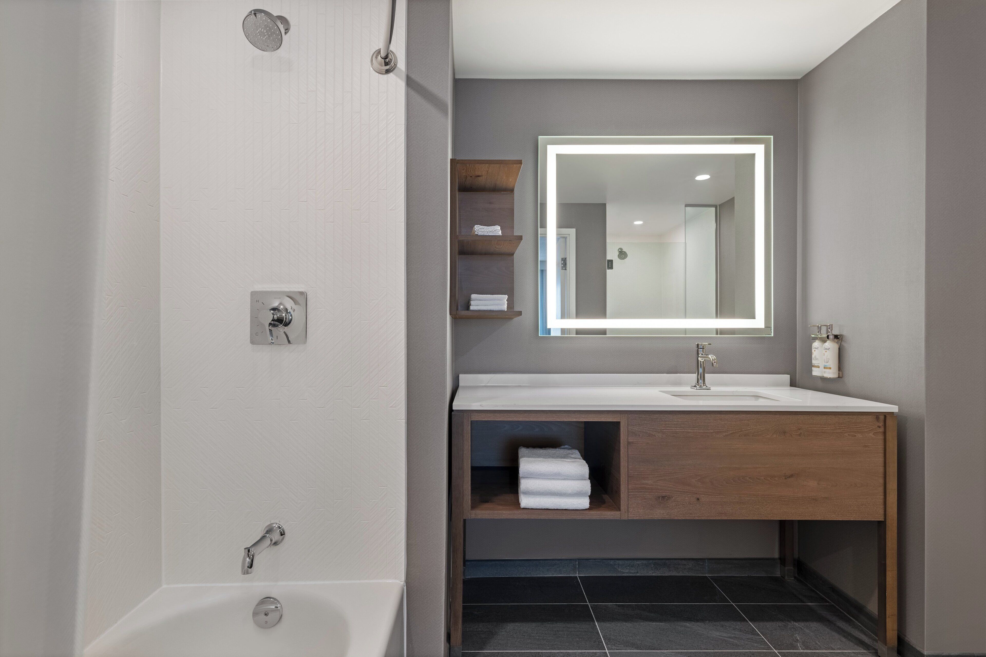 Une salle de bain moderne avec une baignoire, un meuble-lavabo avec un miroir et une douche.