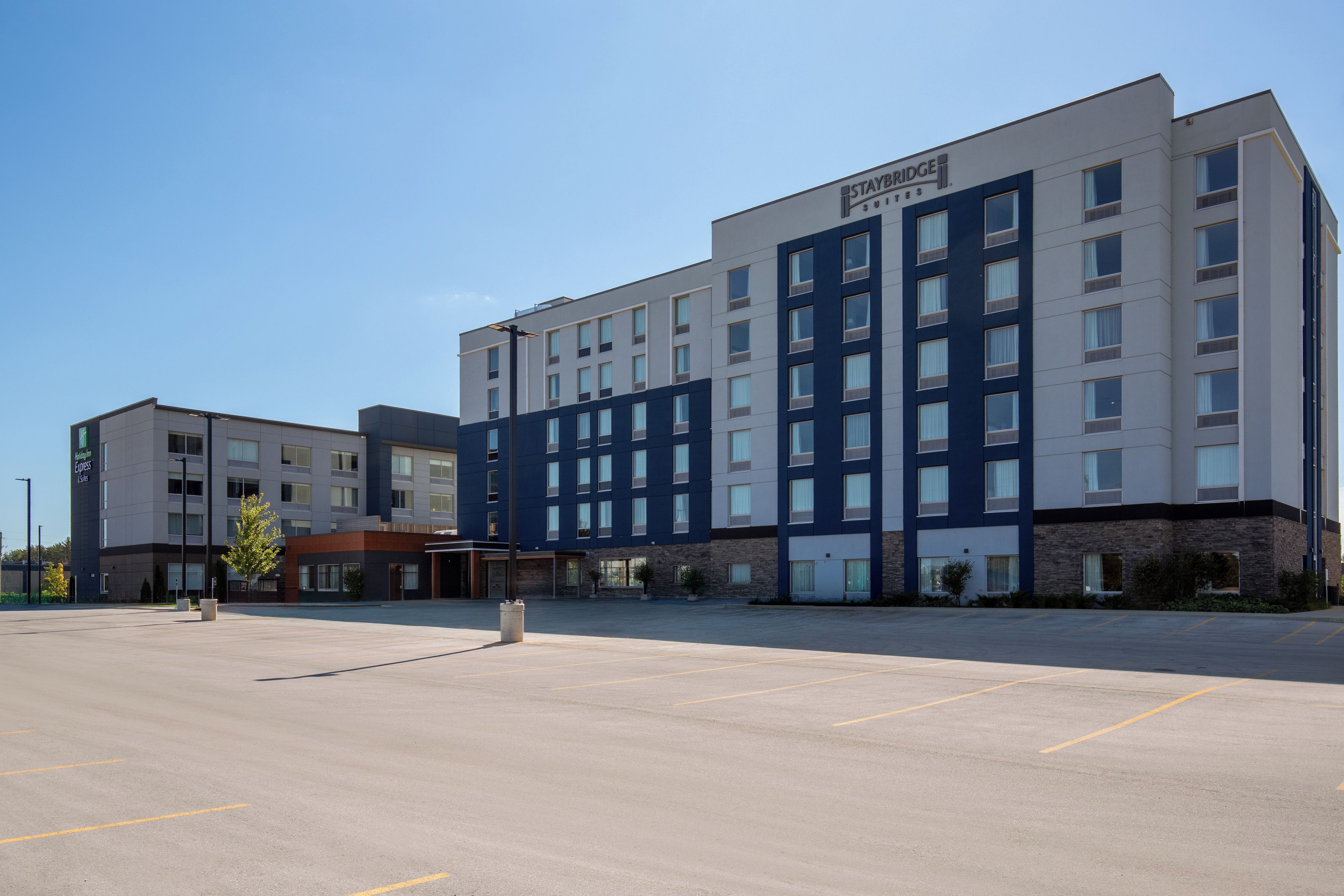 A multi-story hotel with a parking lot in front.