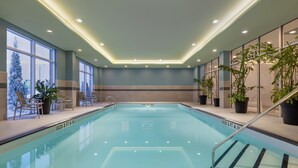 An indoor swimming pool with clear water, surrounded by lounge chairs and potted plants. - Staybridge Suites Port Elgin by IHG (Saugeen Shores)