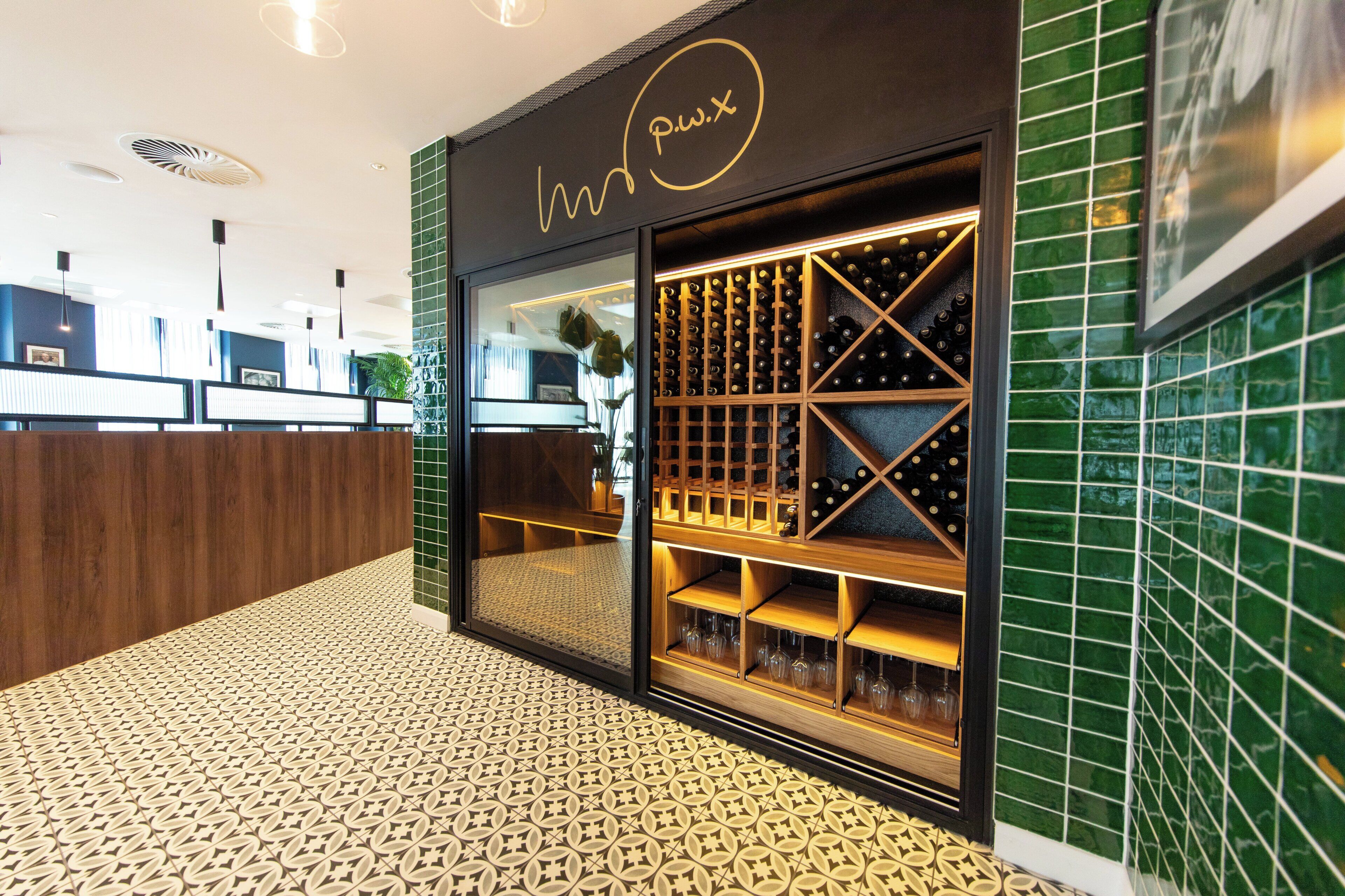 Una bodega con puerta de vidrio, estantes de madera y suelo estampado.