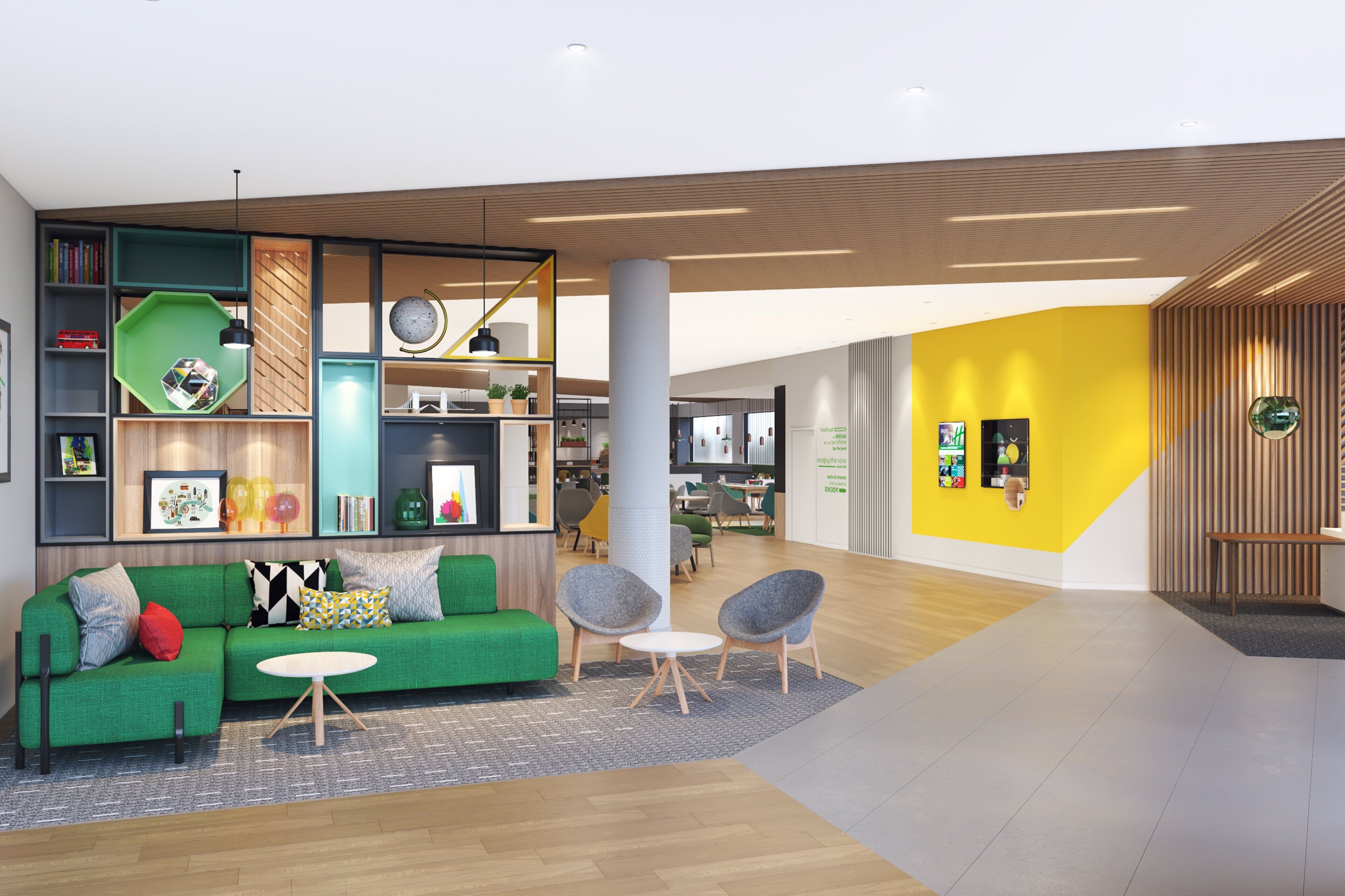 A modern interior with a green sofa, bookshelves, and a yellow accent wall.
