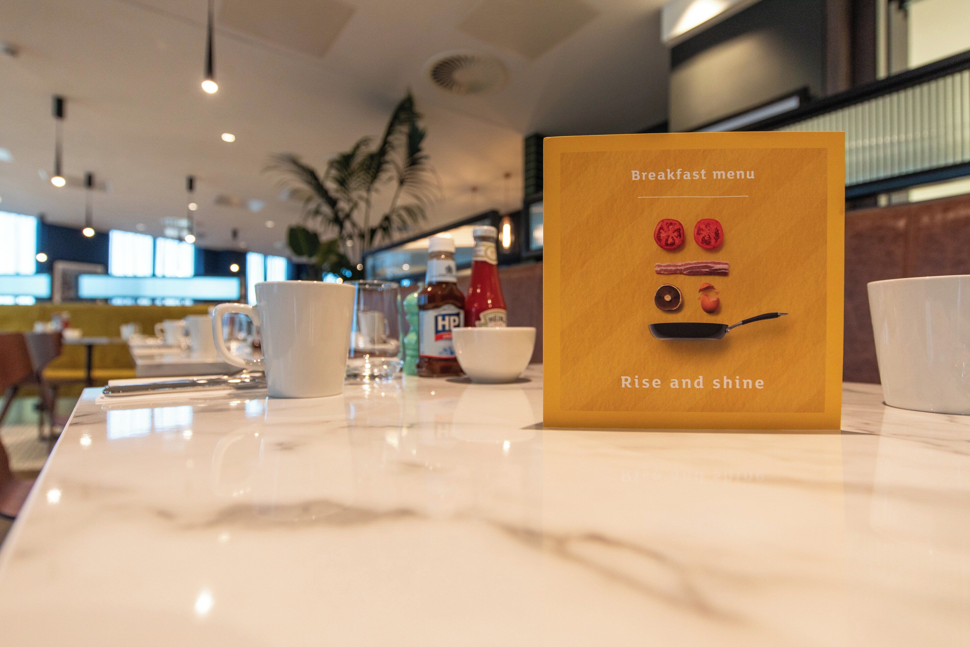 Een kaart met ontbijt aan tafel, met een goed overzicht van de gerechten en het interieur van het restaurant.
