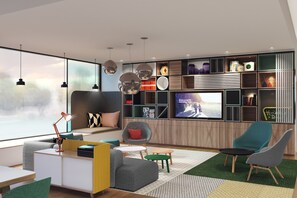 A modern living room with a sofa, chairs, a TV, and a bookshelf. - Holiday Inn Blackpool by IHG (Blackpool)