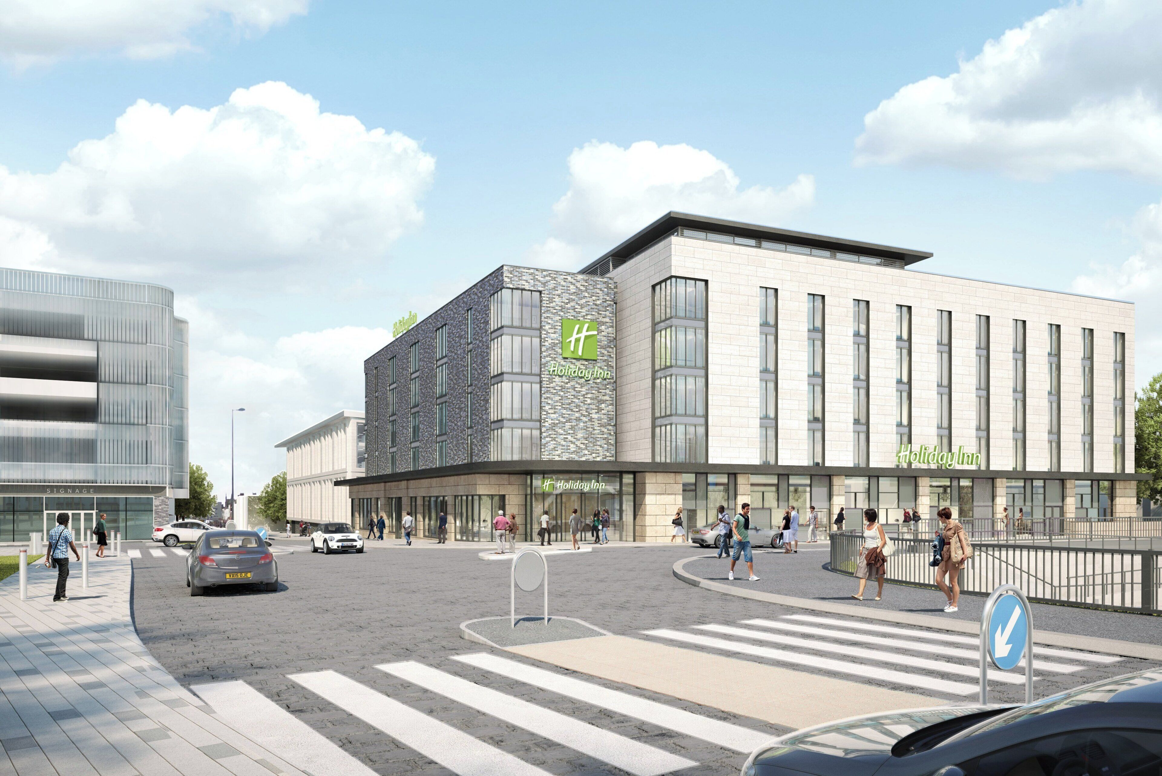 Egy modern Holiday Inn szálloda, jól látható „Holiday Inn” felirattal, egy gyalogosátkelővel és egy parkolóval, ahol autók állnak.