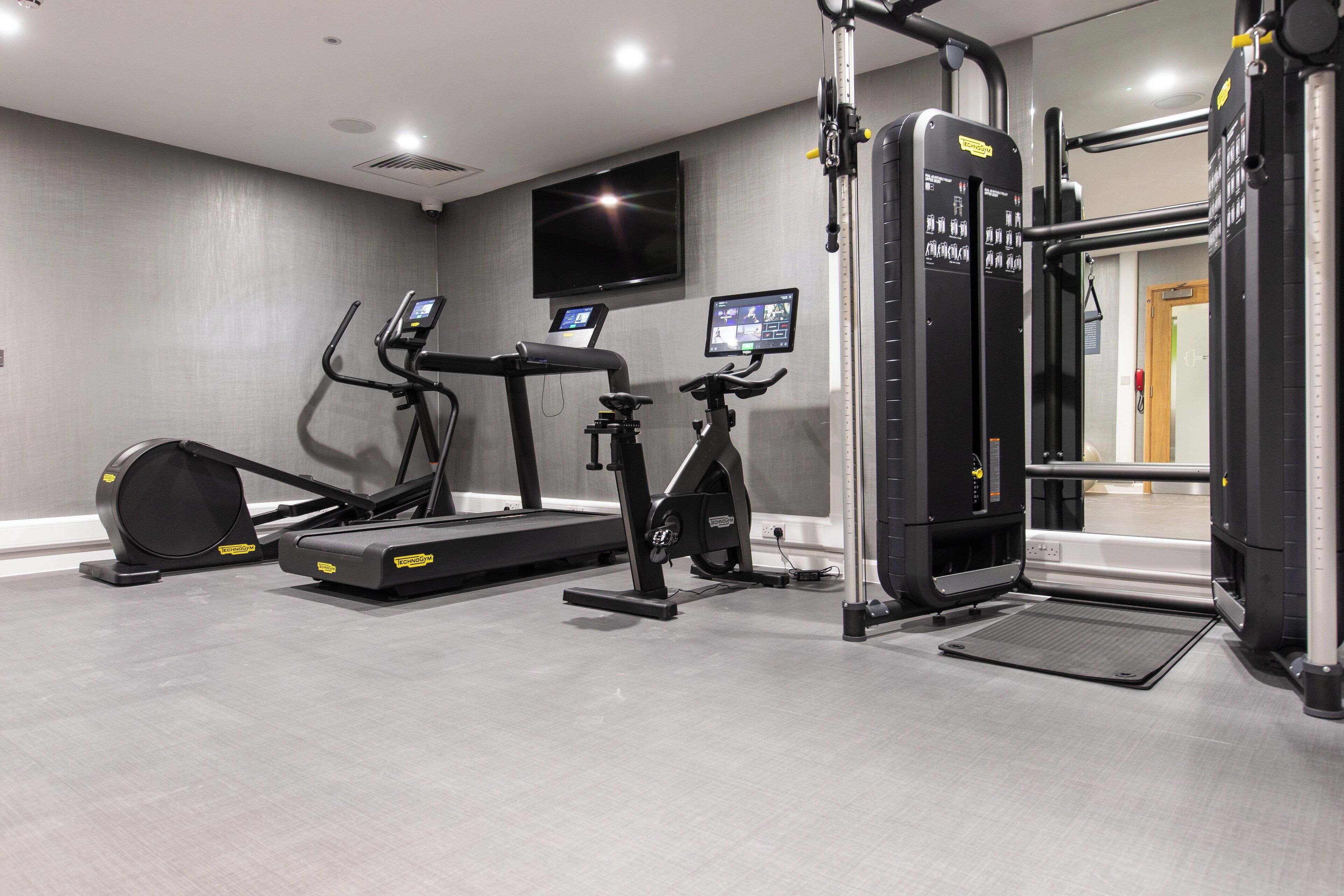 A gym with treadmills, an elliptical, and a weight machine.