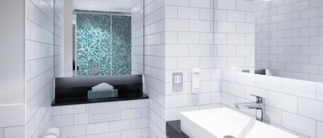 A modern bathroom with white tiles, a black countertop, a white sink, and a mirror.