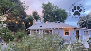 A house with a light blue exterior, surrounded by a garden with various plants and flowers. - Dog-Friendly Home - 1.5 Miles from Red Rocks Amphitheater (Morrison)