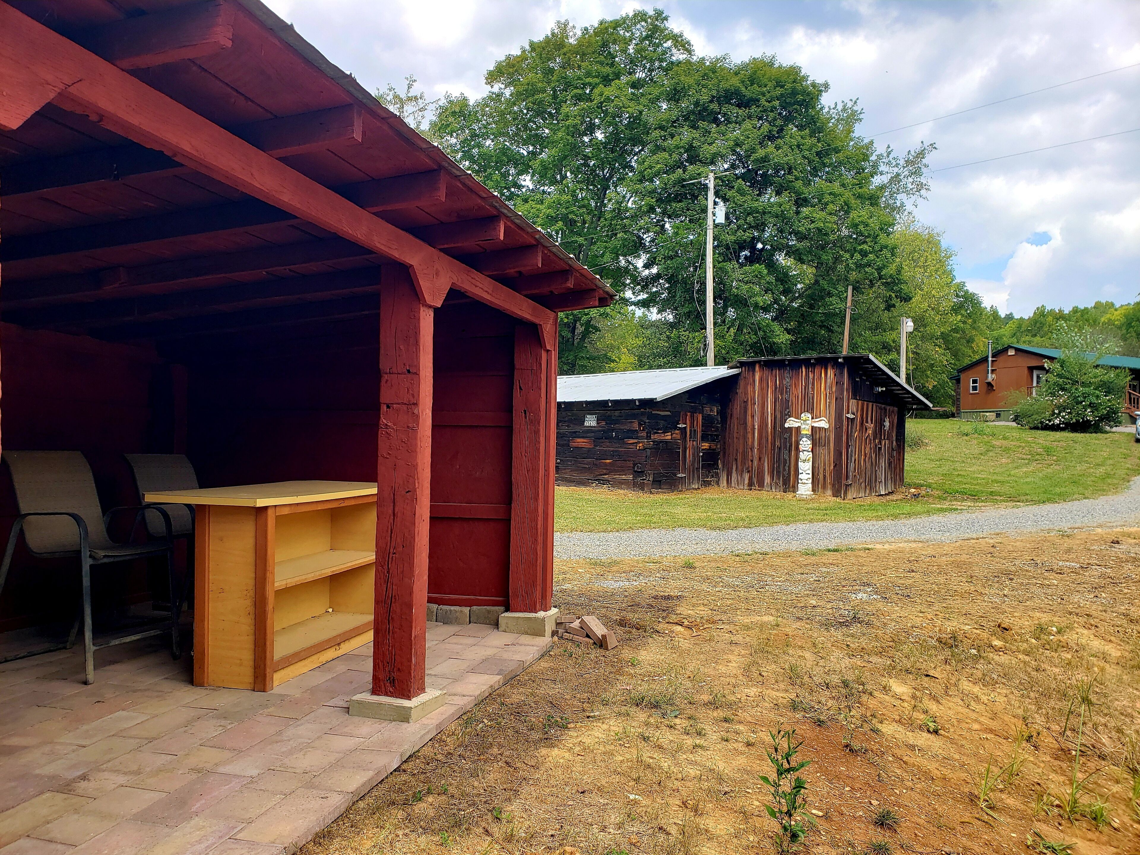A rustic wooden building with a covered porch, a bench, and a table.