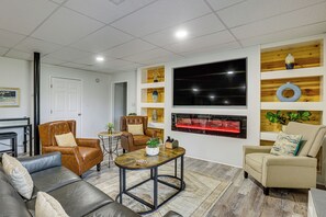 Un salon moderne avec des canapés en cuir, une table basse et une cheminée.