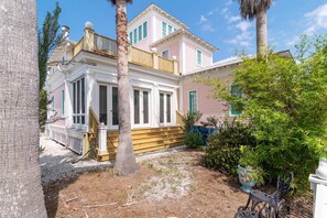 A two-story house with a porch and a small garden area.