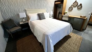 Une chambre d’hôtel moderne, dotée d’un grand lit, d’un bureau et d’une chaise.