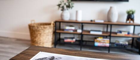 A magazine on a wooden table with a bookshelf in the background.