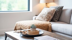 A cozy living room with a sofa, a lamp, and a small succulent plant on a tray. - Revylation by Revelstoke Vacations (Revelstoke)