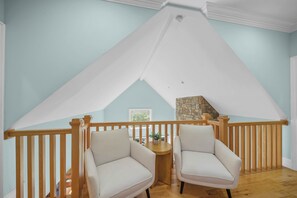 A room with a high ceiling, a stone fireplace, and two chairs. - Mountain Top at Linville Falls: Amazing Views! Hot Tub! Pet Friendly! Near Linville Falls Winery! (Newland)