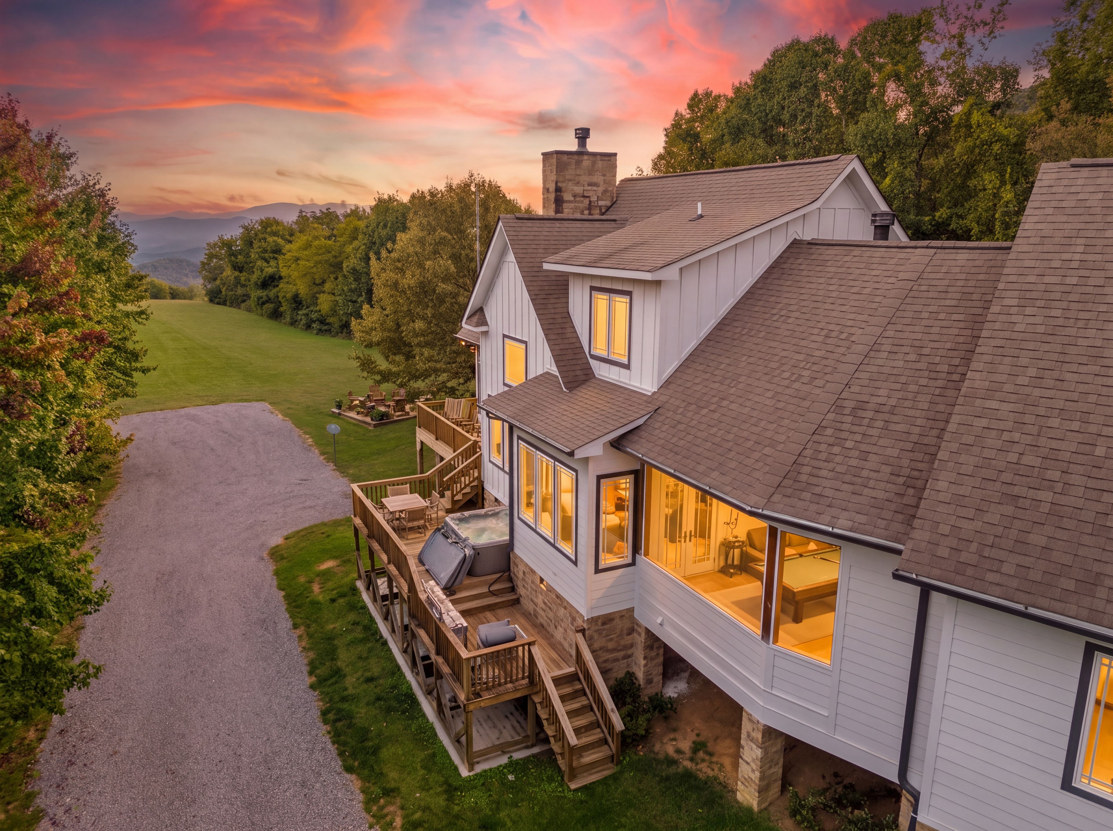 Une maison à deux étages dotée d’une terrasse, d’un jacuzzi et offrant une vue sur le paysage.