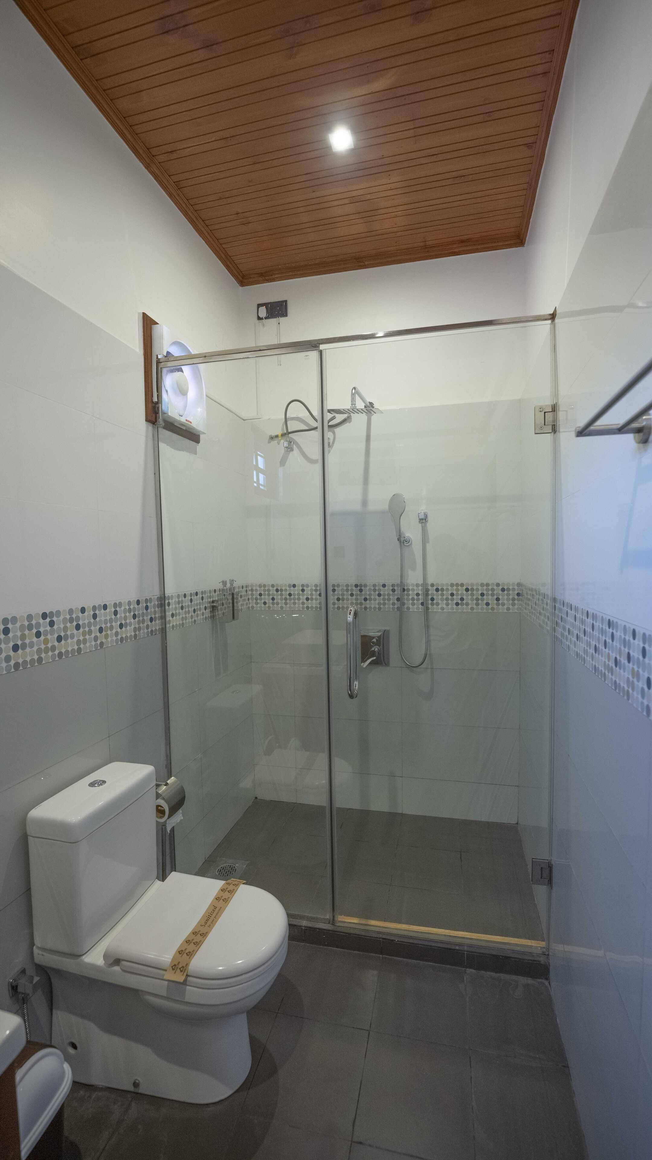 Une salle de bain moderne dotée d’une douche à parois de verre, de toilettes et d’un bidet.