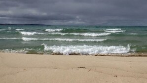 A beach with waves approaching the shore under a cloudy sky. - Spacious home, 12 miles from Nubs Nob, Harbor Springs surrounded by forest. (Alanson)