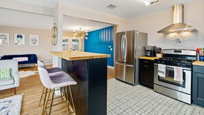 Eine moderne Küche mit einer zentralen Kochinsel, Edelstahlgeräten und einer blauen Akzentwand.
