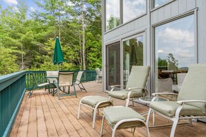 Eine Holzterrasse mit Gartenmöbeln, einem Tisch und Stühlen.