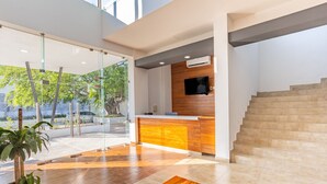 A modern lobby with a wooden reception desk, a flat-screen TV, and a staircase. - WinDay Veracruz Hotel Express (Veracruz)
