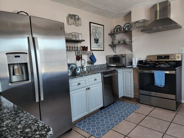 A modern kitchen with stainless steel appliances, a water dispenser, a microwave, and a stove.