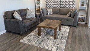 A living room with two sofas, a coffee table, and a bookshelf.