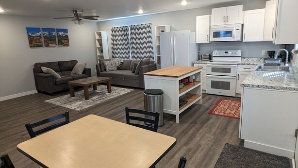 A modern living space with a dining area, kitchen, and seating area.
