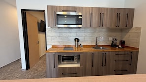 A modern kitchen with a built-in microwave, oven, and sink. - Bushiri's Long Life Building-2BD/1BA APT-Sleeps 4 (Noord)