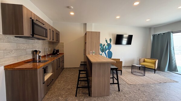 A modern kitchen with a wooden countertop, built-in appliances, and a bar area.
