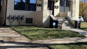 A two-story building with a flat roof, large windows, and a covered front porch. - Newly Renovated Condo's (Detroit)