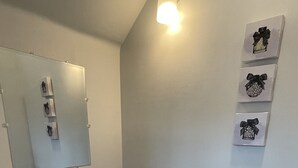 A bathroom with a toilet, sink, mirror, and decorative wall art. - Newly Renovated Condo's (Detroit)