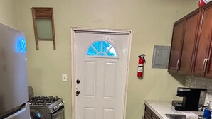 Una cocina equipada con refrigerador, estufa, horno y cafetera.