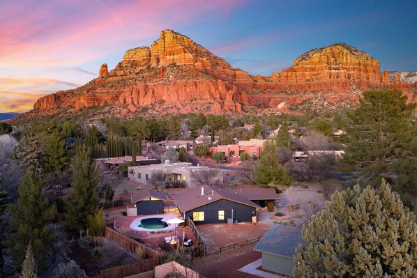 Residential homes with attached garages and lush landscaping surround a community pool.