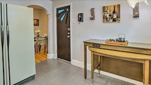 Eine Küche mit einem Holztisch, einem Kühlschrank und einer Tür mit ungewöhnlichem Design.