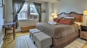 A bedroom with a bed, a desk, and a chair.