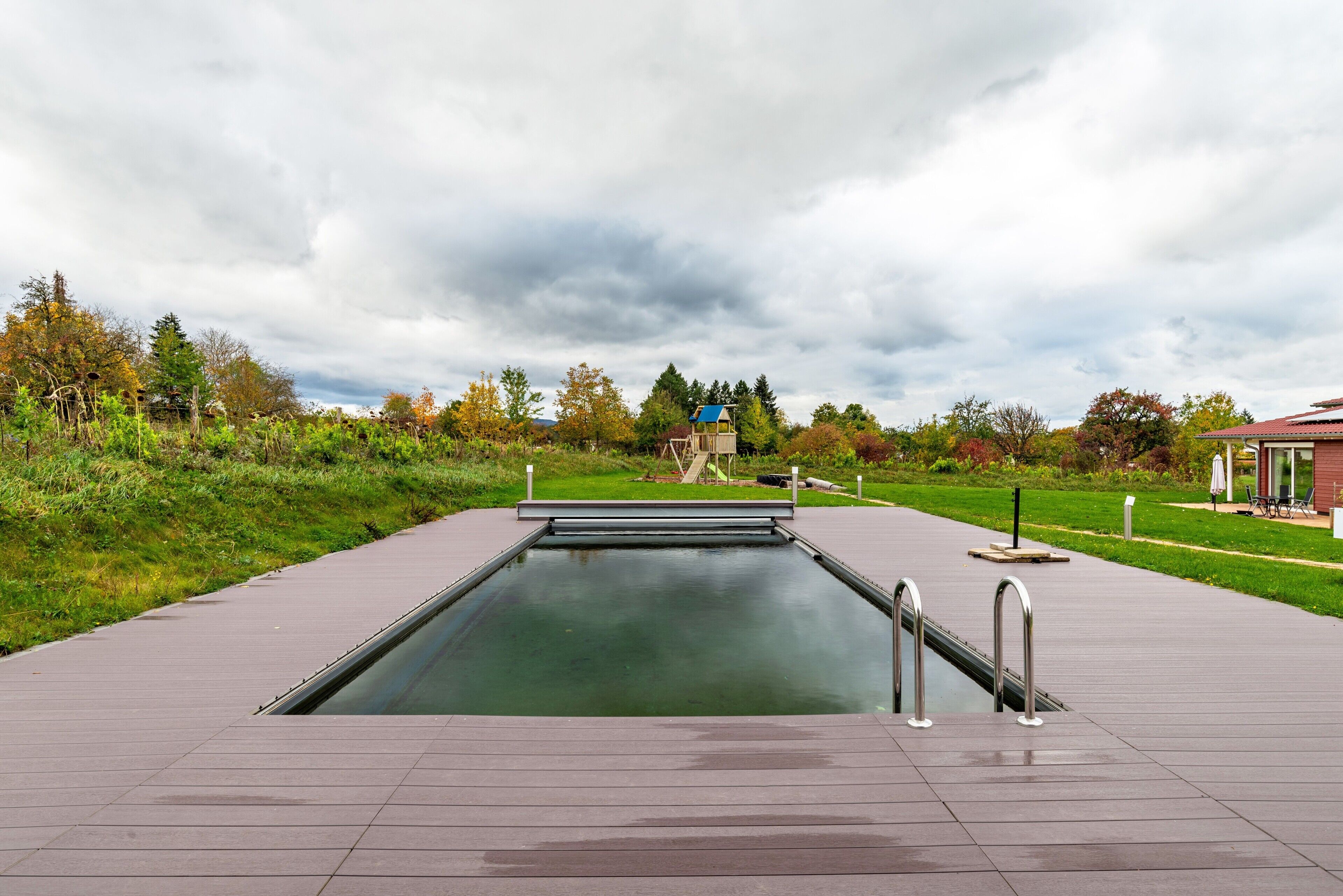 Ein Schwimmbecken mit freiem Blick auf den Himmel und die umliegende Vegetation.