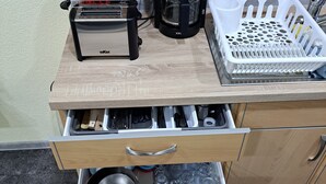 A kitchen with a toaster, coffee maker, and a basket of utensils on a wooden countertop. - Holiday Apartment " In Elz" with Wi-Fi (Elz)