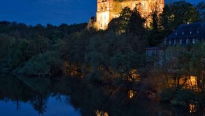 A castle with multiple towers, surrounded by trees and a body of water reflecting the structure. - Holiday Apartment " In Elz" with Wi-Fi (Elz)