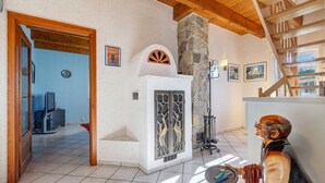 A room with a stone fireplace, wooden ceiling beams, and a staircase. - Holiday Home 'Ferienwohnung Im Grünen' with Shared Terrace and Wi-Fi (Bissendorf)