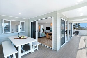 Une cuisine moderne dotée d’un réfrigérateur encastré et d’un coin repas avec une table et des bancs blancs.
