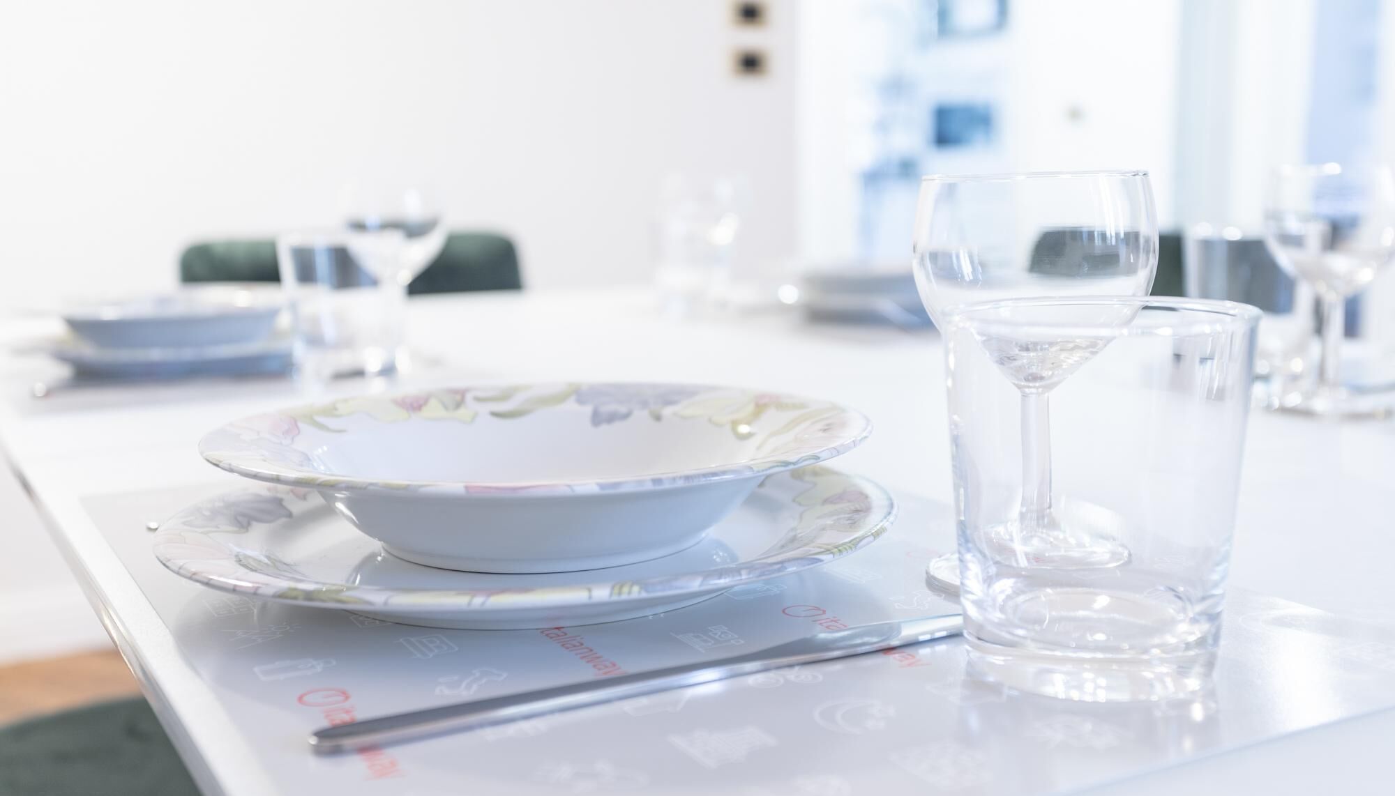 A table set with a bowl, a glass of water, and a pen.