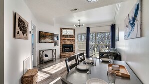 A modern dining area with a wooden table, chairs, and a fireplace.